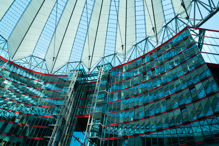Berlin Germany - August 25 2017; Inside magnificent central forum of Sony Centre on Potsdamer Platz with sky through vaulted shaped glass roof high overheadのeditorial素材