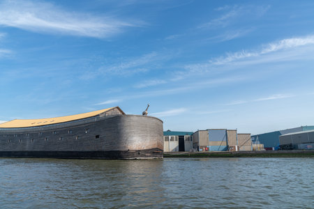 Large wooden plank constructed boat along New Meuse River with giraffe standing on stern, Rotterdam...