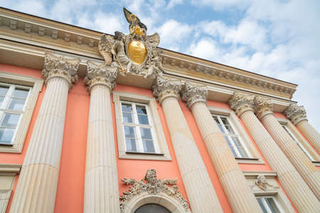 Potsdam Germany - August 27 2017; Exterior facade of City Palace from low point of view looking upwards at ornate feature with golden crest with crown between pillarsのeditorial素材