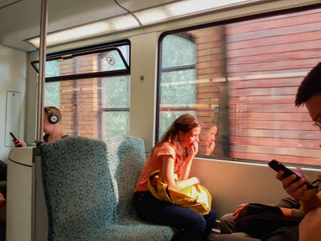 Berlin, Germany - August 26 2017; Young woman sit on-board looking out with point of focus on reflection in windowのeditorial素材