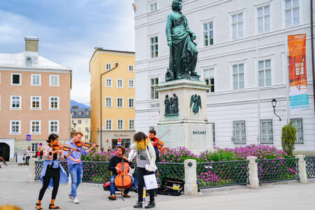 Salzburg Austria - September 6 2017 Group of musicians perform in street of city town square under statue of Mozart.のeditorial素材