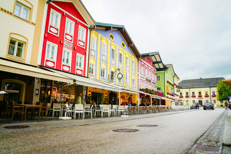 Mondsee Austria - September 6 2017; Small town street lined by typical buildings with colorful facades and gables with outdoor dining settings.のeditorial素材