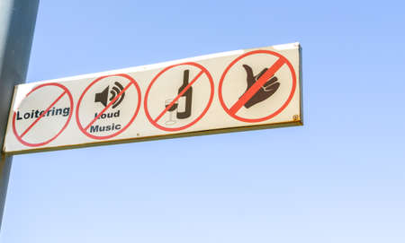 Banned activity sign showing activities not allowed against blue sky.の写真素材