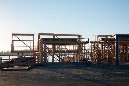 New day, new home wooden framing of new home under construction back-lit by rising sun.の写真素材