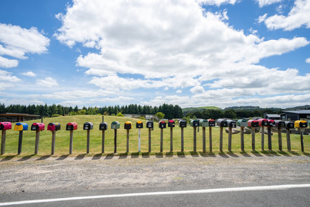 Taupo New Zealand - November 27 2021; Long row of letterboxes and shadows along rural road near...