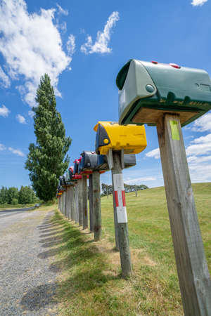 Long row of letterboxes and shadows along rural road near Kinloch, Taupo, New Zelandの写真素材