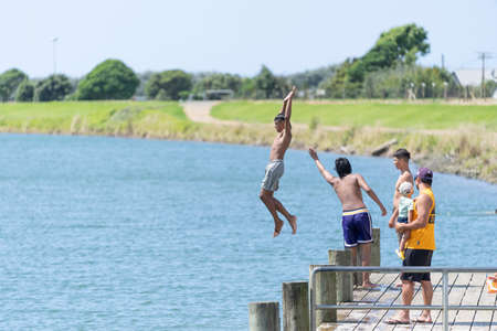 Opotiki New Zealand - January 30 2022; Young people jumping into Otara River enjoying summer funのeditorial素材