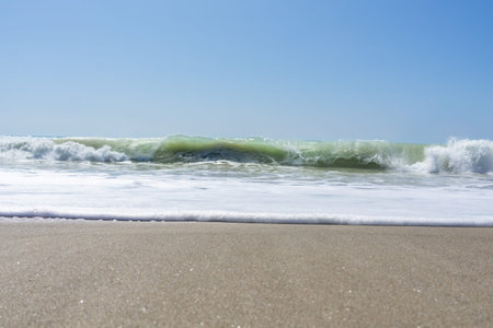 Tokomaru Bay beach with surf waves crashing onto beach, New Zealand.