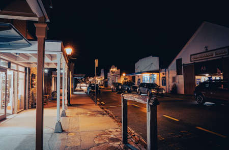 Arrowtown New Zealand - April 21 2022; Nighttime in main street in heritage village street lights, and shop fronts lining both sides of road.のeditorial素材