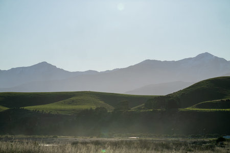 Landscape view towards Kaikoura Seaward mountains from lookout in hazy evening light.