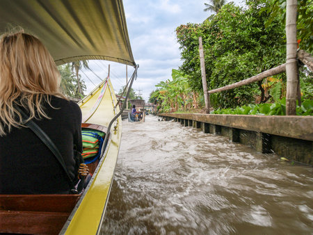 Bangkok Thailand - August 10 2007; Yellow Long-tail river transport boast moving up river to floating market.のeditorial素材