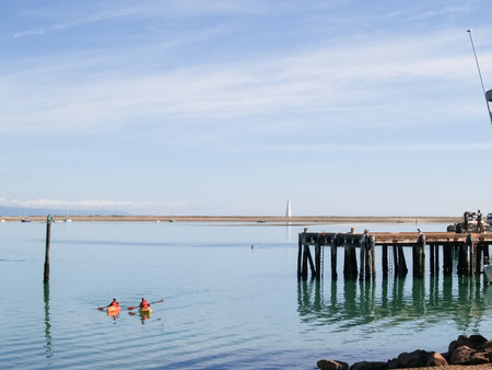 Nelson New Zealand - February 23 2007; Two kayakers arriving back at beach beside pier on waterfront.のeditorial素材