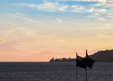 Dusk coloured sky over silhouette foreground of lake and hills