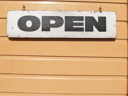 Word OPEN on sign in black and white attached to exterior wall.の写真素材