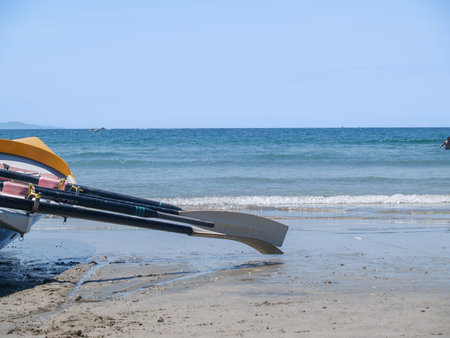 Surf-boat sitting at waters edge of ocean beach view to horizon.