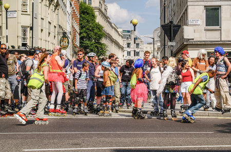 Large group diverse people meet-up on city street for a roller-blade street outing.