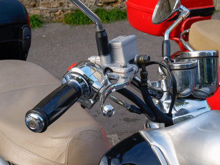 Handbrake on Motorcycle handle bars and dials closeup parked in city street.