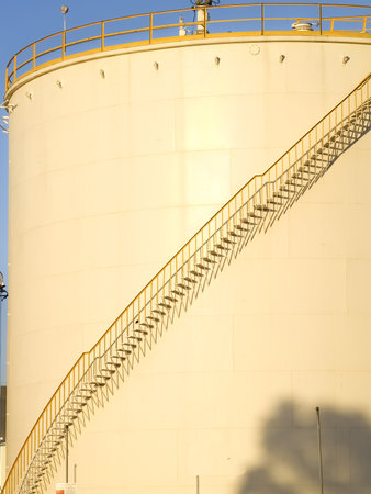 Large circular fuel storage tanks against blue sky.の写真素材