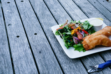 Fish with golden batter and salad meal on plate tasty and ready to eatの写真素材