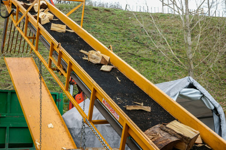 Log splitter conveyor with split timber and danger keep clear sign.の写真素材