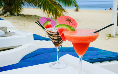 Tropical cocktails table by sun-lounger on beach at Rarotonga Cook Islands.の写真素材