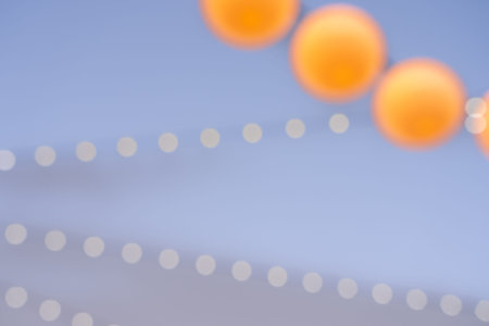 Round orange coloured spheres in abstract defocused pattern overhead.