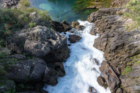 Algae tints rock pool turquoise  as water gushes in after opening Aratiatia dam gates at Taupo on Waikato River.の写真素材