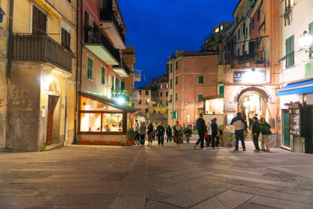 Riomaggiore Italy - April 24 2011; People blurred in motion moving  about on street at night in...