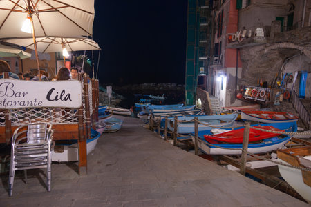 Riomaggiore Italy - April 28 2011; Ancient fishing village boats pulled up between homes and restaurant on dockのeditorial素材