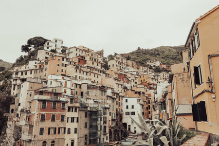 Riomaggiore Italy - April 23 2011; Traditional style rustic homes and hills in typical Italian fishing village in vintage effect.のeditorial素材