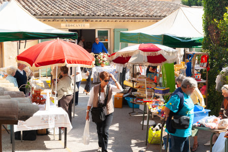 Saint Paul de Vence, Provence,  France -May 2 2011; Typical weekend flea market with patrons blurred in motion as they lood at offeringsのeditorial素材
