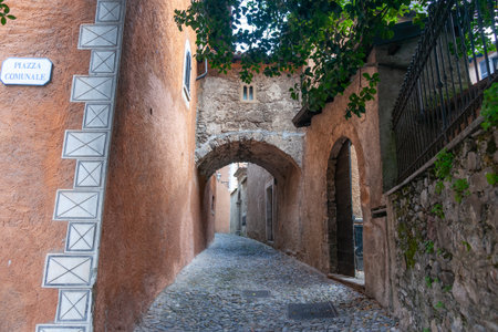 Lane leading from Piazza Comunale betweem exterior walls and under stone arch connecting bridge in Como.の写真素材