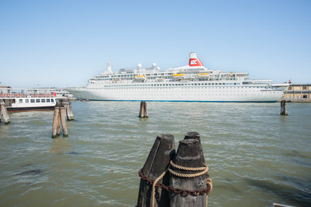 Venice Italy - May 10 2011; Cruise liner berthed in port with ferry tied alongside  on sunny clear sky day.のeditorial素材