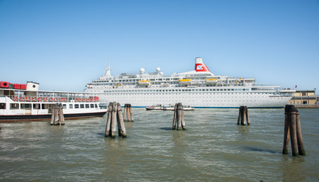 Venice Italy - May 10 2011; Cruise liner depart port with berthed ferry tied alongside  on sunny clear sky day.のeditorial素材