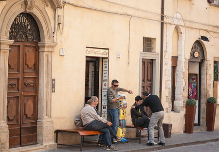 Gubbio Italy - May 12 2011; Two generations of males in street outside cafe door.のeditorial素材