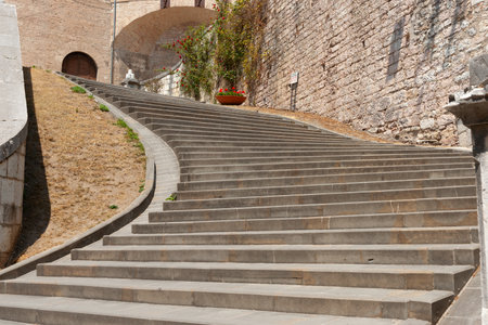 Gubbio Italy - May 13 2011; Wide concrete steps leading upward to arched entrance and turning left.のeditorial素材