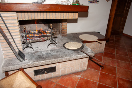 Umbria, Italy, May 14 2011; Traditional Italian pizza cooking in open fireplaceのeditorial素材