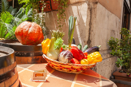 Rome-Italy - May 19 2011; Basket of vegetables and a pumpkin on table display outside restaurant in city streetのeditorial素材
