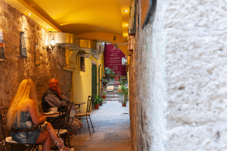 Split Croatia - May 26 2011: Couple sit with tea in narrow corridor entrance to old town tea house.のeditorial素材