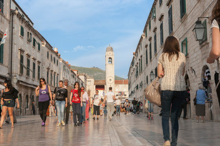 Dubrovnik Croatia - May 28 2011; People on European old town street bordered by medieval buildings with Orlando's column.のeditorial素材