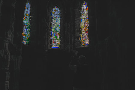 Background of back-lit religious stained glass windows set in stone wall.の写真素材