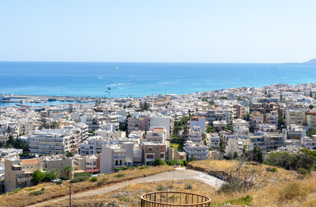 downhill view to residential rooftops and port in coastal town Rethimno on Crete with sea and horizon beyond.の写真素材