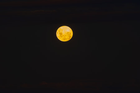 Golden glow of Moon on dark sky background.の写真素材