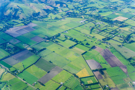 Patterned rural landscape below with shadows from clouds.