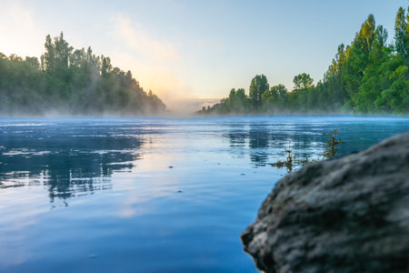 Early morning mist rises from Clutha River Cromwell in Central Otago New Zealand.
