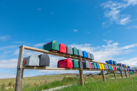 Rows if multi-coloured rural letterboxes on country road.