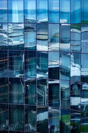 Windows reflections in grid pattern on side of commercial building.