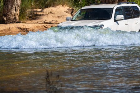 4x4 vehicle driving through or across riveron expedition in Western Australian outback.