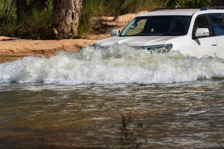 4x4 vehicle driving through or across riveron expedition in Western Australian outback.の写真素材