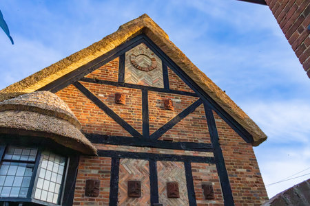 Horning United Kingdom - July 6 2025; Exterior wall of building displaying brick, half timber and thatch roof construction types in Horning Norfolk Broads, United Kingdom.の写真素材
